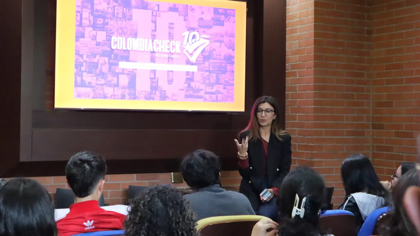 Una periodista de Colombiacheck da una charla frente a la presentación de los 10 años