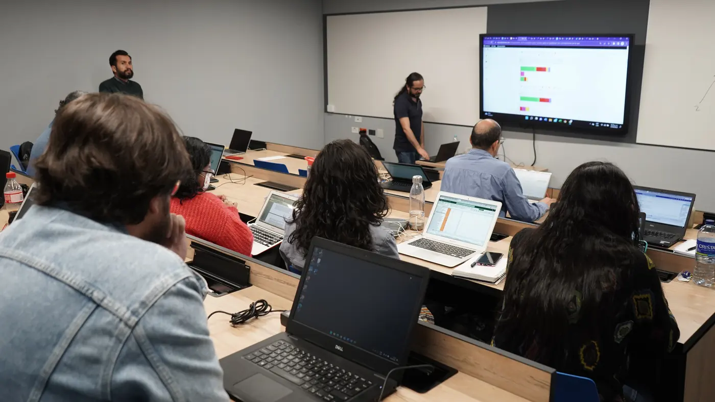 Clase del diplomado: estudiantes con portátiles y formadores junto a la pantalla