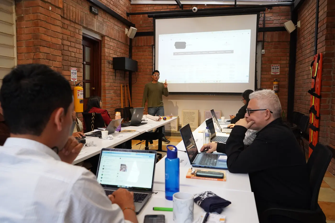 El equipo capacitador de Colombiacheck dirige una sesión con proyector