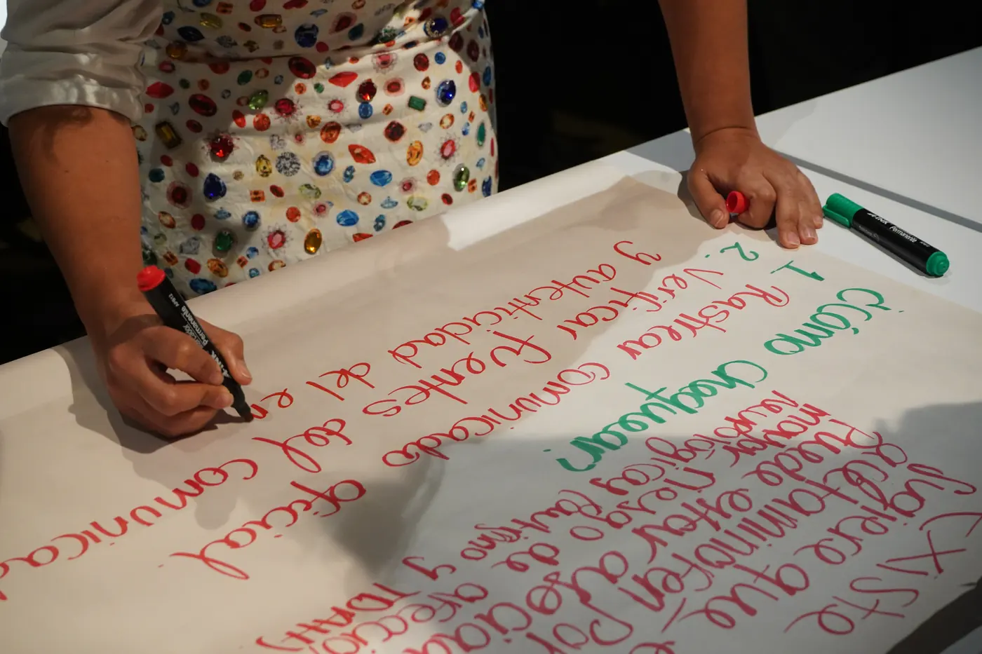 Una participante escribe en un papelógrafo los pasos de «¿Cómo chequear?»