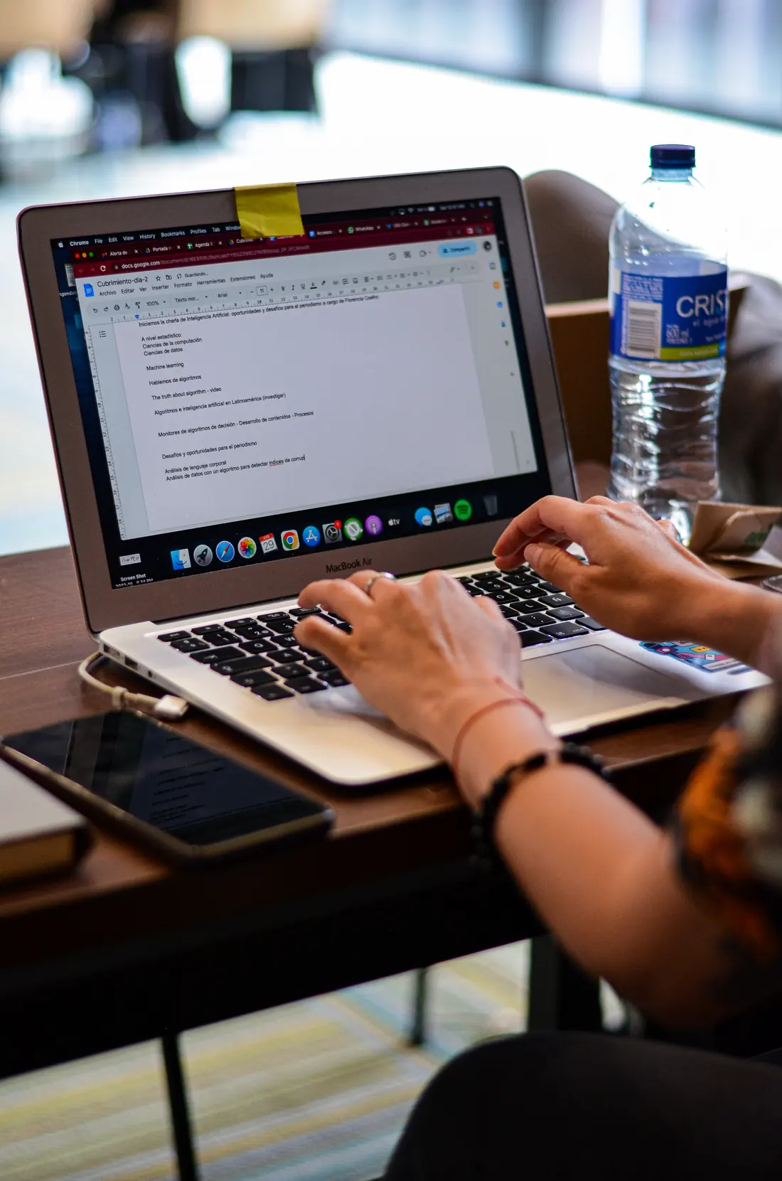 Manos escribiendo en un portátil durante una sesión de trabajo