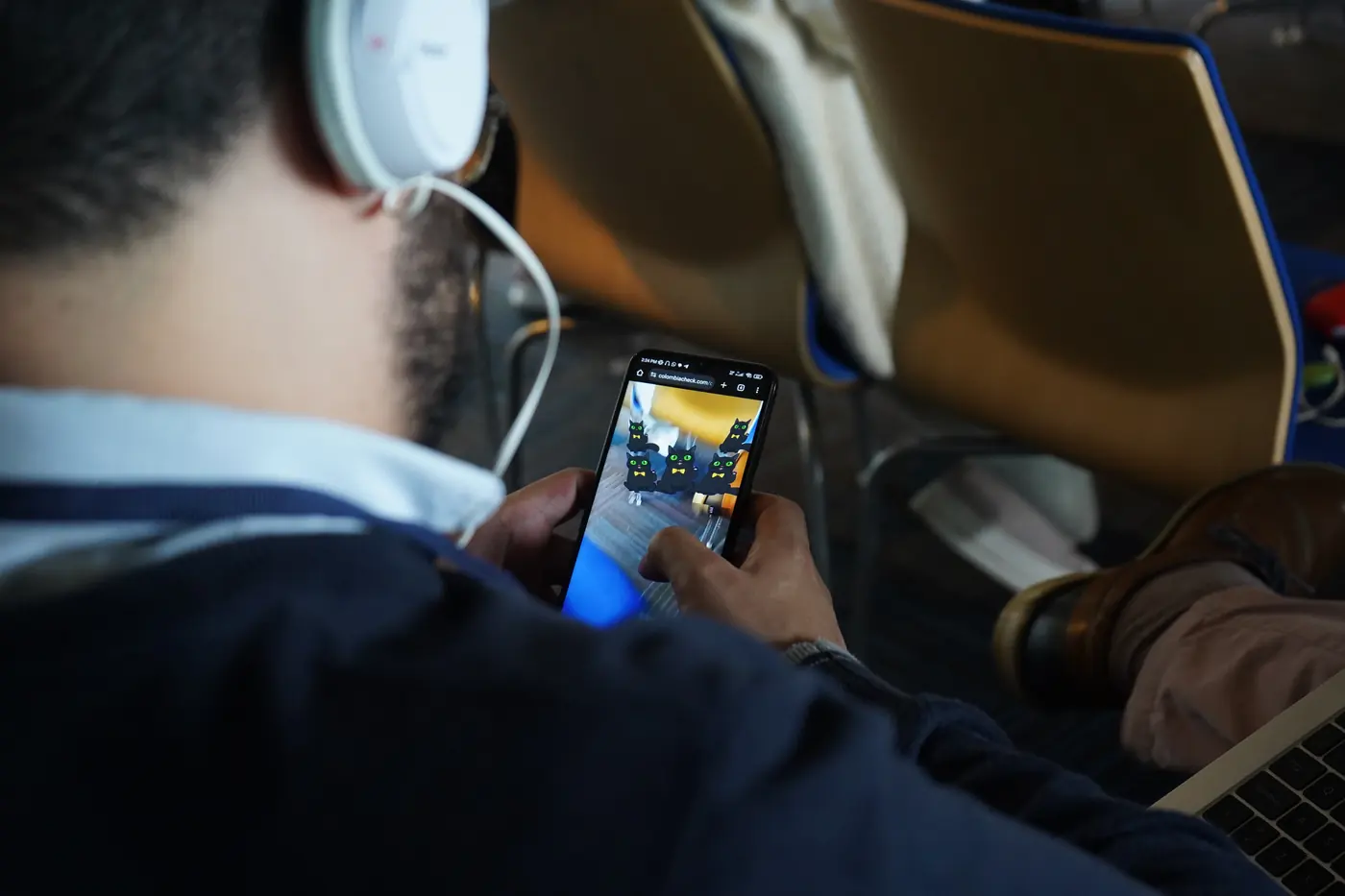 Un participante con audífonos prueba en su celular una experiencia de realidad aumentada
